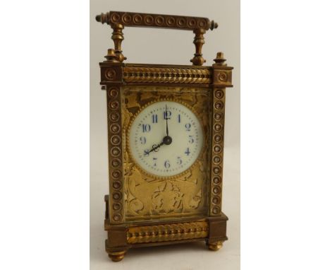 A gilt metal cased carriage clock, with enameled circular dial, the gilt front decorated with mythical beasts, height includi