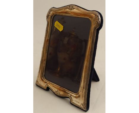 A hallmarked silver mounted photograph frame, with embossed decoration and easel back, aperture size 5.5ins x 3.5ins