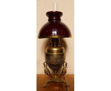 A brass oil lamp, the base embossed with a Classical band on three stylised birds to a triform base, marked Sherwoods Ltd Bir