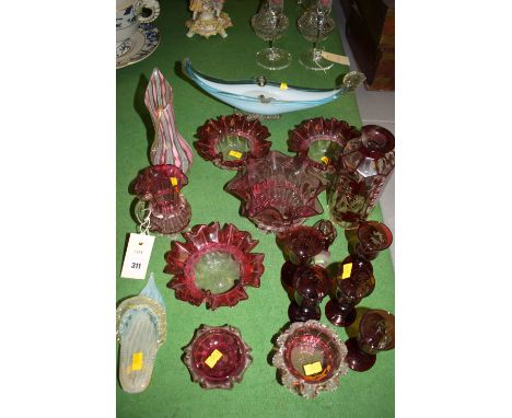 A collection of mainly 19th Century cranberry glassware, comprising: four bowls with wavy rims; a similar jug; a glass shoe p