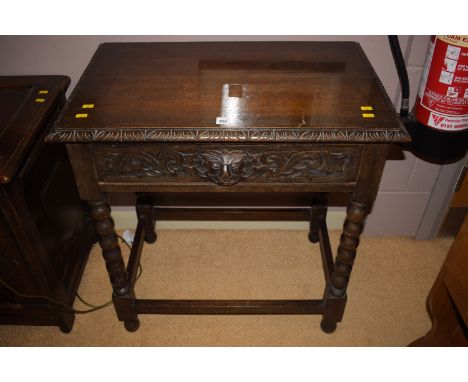A 19th Century carved oak side table with mask pattern handle to frieze drawer, raised on bobbin turned legs, 27in. wide.