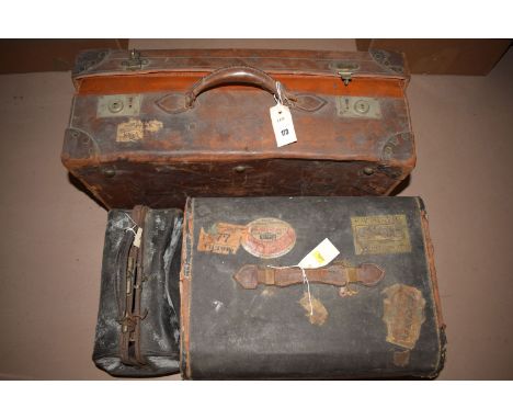 An early 20th Century leather suitcase with initials 'I.W.'; together with a small trunk; and a Gladstone bag with various la