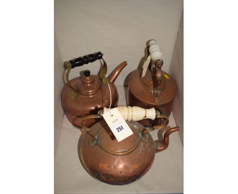 Two antique copper kettles with ceramic handles; and a modern copper kettle.