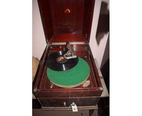 A vintage His Masters Voice wind-up gramophone in mahogany case; together with a small collection of 78 rpm records.