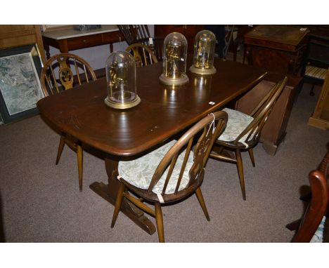 An Ercol dark stained elm dining table; together with four chairs with pierced and spindle back.