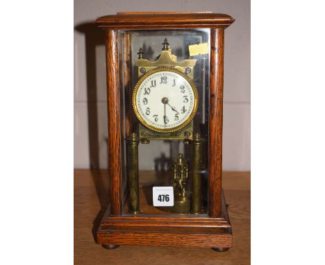 A brass anniversary mantel clock, stamped 122203, with revolving pendulum in oak case with glass panels.