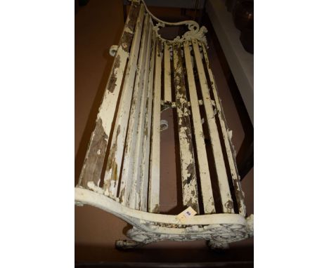 A cast iron and white painted wooden slatted garden bench, the ends of scrolling design with lion fronts, 62in. wide.