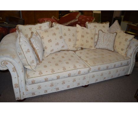 A sofa, fitted loose seat and scatter back cushions, decorated with monogram designs, by Gascoigne.