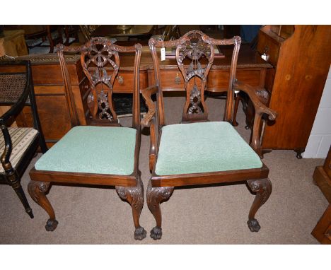 A set of eight Chippendale style mahogany dining chairs, to include two open arm and six single chairs, each with scrolling s