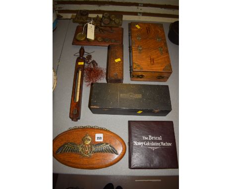 An oval wooden plaque with a carved and painted RAF badge featuring the crown and wings; a Brical money calculating machine, 