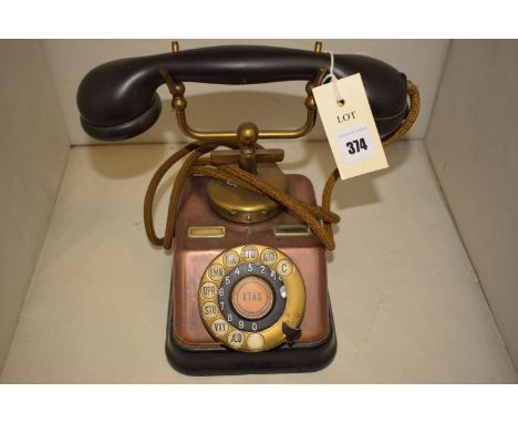 A vintage Danish telephone set in brass and copper, the circular finger dial inscribed 'KTAS', fitted with a bakelite handset