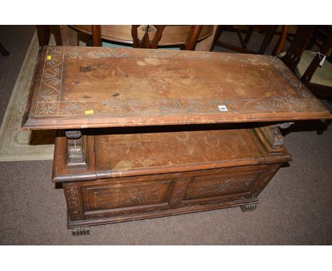 An oak monks bench with carved top and lion pattern arms and box seat, 41in. wide.