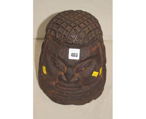 An African carved wooden ornamental helmet in the form of a head.