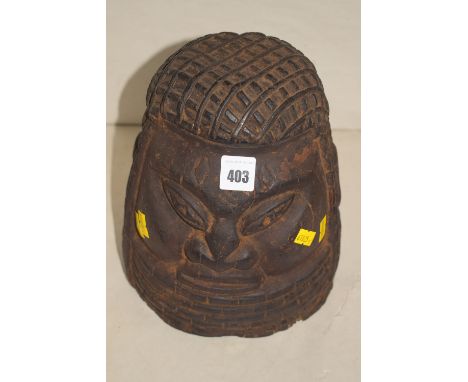 An African carved wooden ornamental helmet in the form of a head.