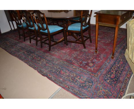 A Persian Tabriz carpet, the open claret field with floral sprays, 475 x 287cms.