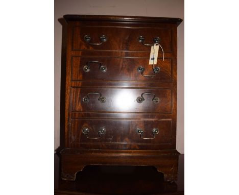 A reproduction cabinet, the hinged top above four false drawers, raised on bracket feet, 24 1/2in. high.