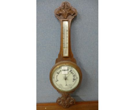 A carved oak aneroid barometer 