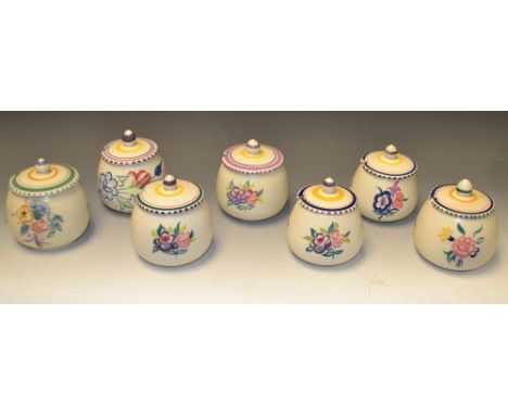 A Poole pottery preserve jar and cover, painted with flowers, impressed marks, others (7)