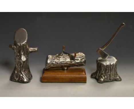 A novelty hand crafted miniature silver coloured metal tree stump and axe; two others, similar, tree stump, log with wood saw