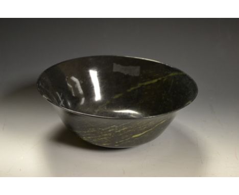 A Chinese spinach green jade bowl, of flared rim, of a dark green/black hue with strains of lighter green 20cm diam 