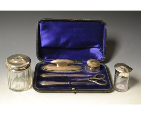 A silver engine turned five piece manicure set, blue velvet lined  Morocco case, Birmingham 1939; two similar silver mounted 