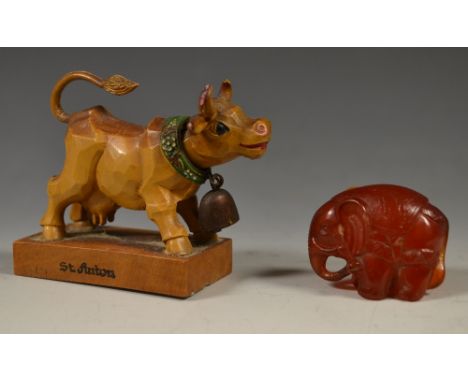 A Japanese amber coloured netsuke, as an adorned elephant, signed;a continental St Auton nodding head cow (2)