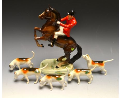 A Beswick six piece hunting group comprising rearing hunstman, red jacket brown horse and five assorted hounds (6).