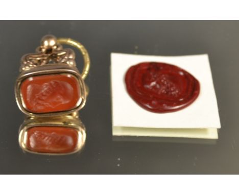 A Georgian cornelian and yellow metal seal fob, the matrix engraved with a portrait of a bearded gentleman and an example of 