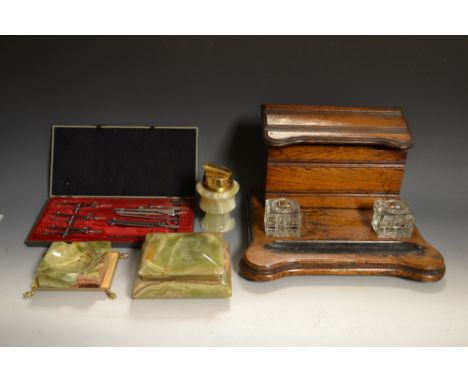 An Edwardian oak stationary rack ink stand, sloping lid enclosing fitted interior pen tray, two inkwells; green onyx cigarett