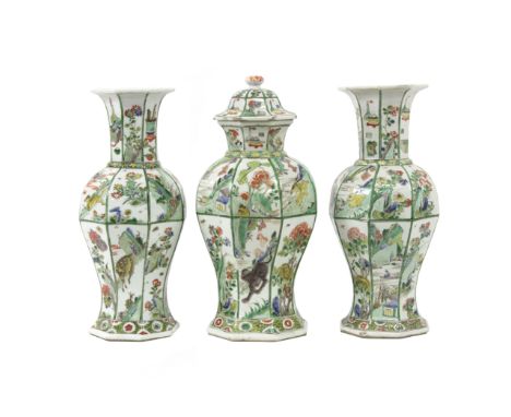 A garniture of three Chinese vases, Kangxi, of octagonal baluster form painted in the famille verte palette with panels of an