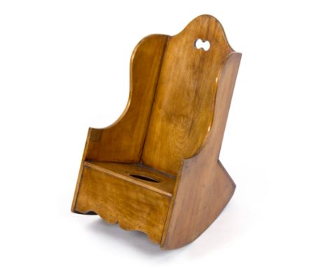 A child's Welsh fruitwood rocking chair with pierced twin roundel to the back, commode seat and shaped apron beneath