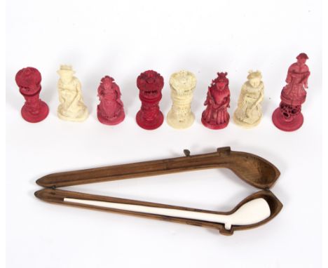 Eight carved and stained red ivory chess pieces, various and a clay pipe in a fitted case