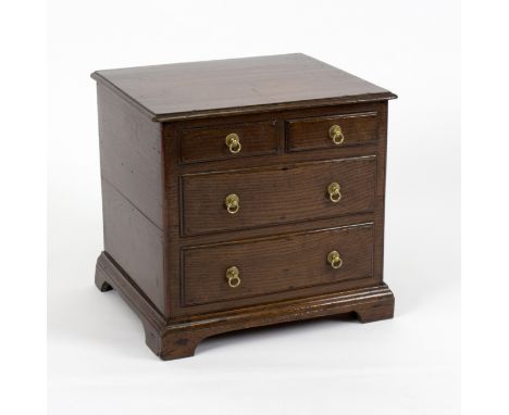 An early 18th Century oak commode in the form of a miniature chest of two short and two long dummy drawers