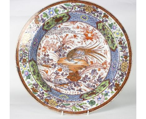 An 18th Century clobbered Chinese circular basin, possibly Dutch decorated, finely painted a central pheasant in a flowering 