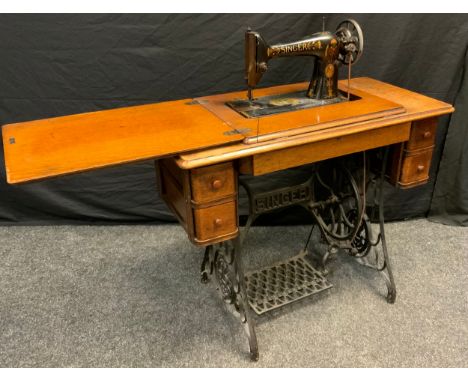 An early 20th century Singer Treadle sewing machine, oak and cast iron base, with an arrangement of five drawers, model/item 