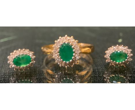 An emerald and diamond oval cluster ring, central emerald approx 0.50ct surrounded by fifteen brilliant cut diamond accents, 