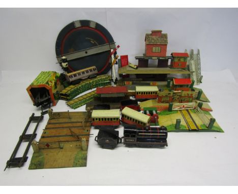 A collection of playworn 0 gauge model railway rolling stock, accessories and spares including Wells 0-4-0 locomotive no.6704