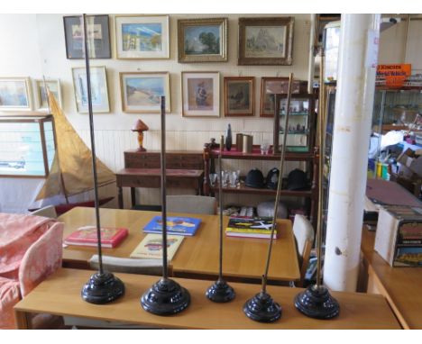 A Collection of Five Shop Display Stands with black glazed ceramic bases and brass columns