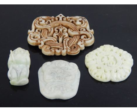 Four Chinese jade pendants: dragons coiled around a ring, 7.3cm w, bats around central symbols, 5cm dia, a warrior and face, 