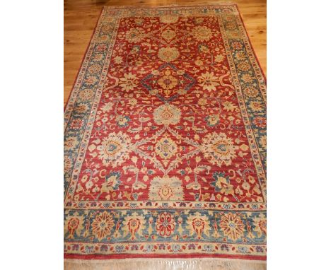 Kazak carpet, scrolling foliate design over red ground within flowerhead cream and blue borders, 307cm l, 200cm w 