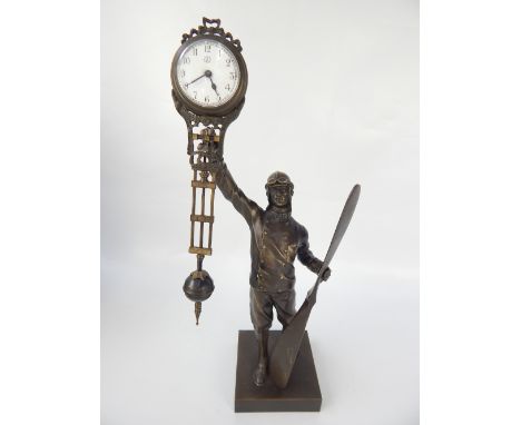 Novelty clock, modelled as a WWI aviator holding the dial aloft with a propeller in the other hand, 38cm h