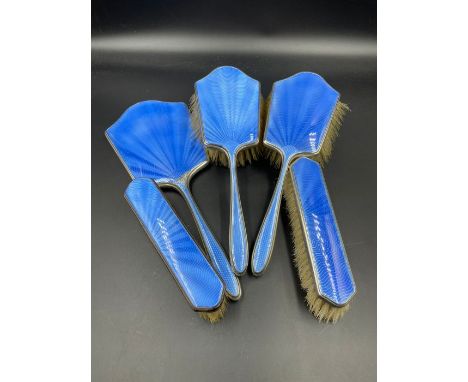 A Five piece silver and blue enamel vanity set to include four brushes and a handheld mirror by Albert Carter Birmingham 1930