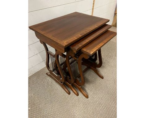 A nest of three tables with harp design to sides (H55cm W51cm D36cm)