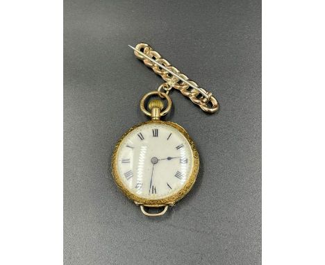 A Ladies 15 ct gold and enamel fob watch on a 9ct gold bar brooch with floral design.