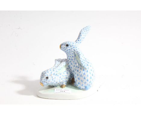 Herend model of two rabbits, by Eva Vastagh, with a shaped base with marks "Vastag Eva 1928", with a blue fish scale design, 