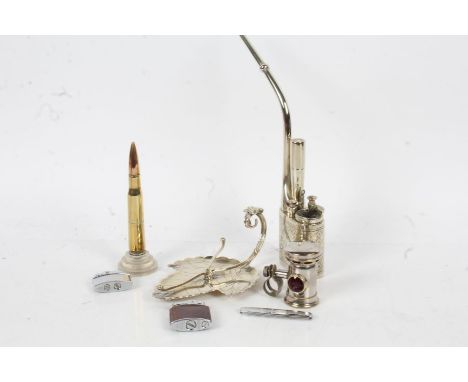 Mixed works of art, to include a Chinese white metal opium pipe, three Ronson lighters, a brass shell case converted to a lig