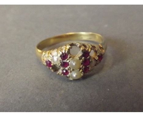 An unmarked 15ct ruby and seed pearl dress ring, size L