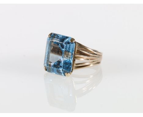 9ct gold dress ring set with large emerald cut aquamarine blue coloured stone, ring size P, 11.5g gross. 