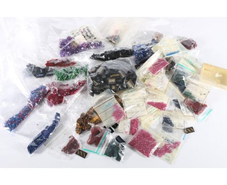 Group of uncut semi-precious gem stone to include tiger's eye, synthetic ruby red stones, etc. 