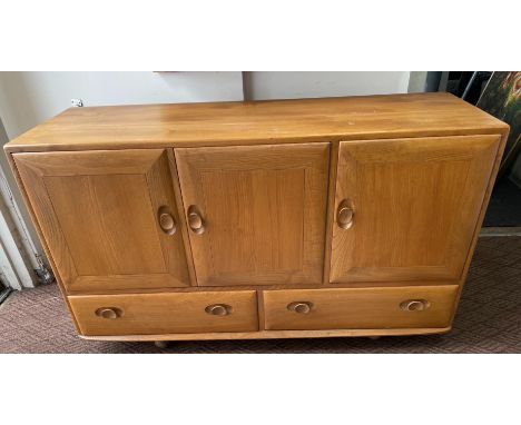 An ERCOL sideboard in light wood finish, two cupboards and two drawers, ERCOL label to the inside - dimensions length 130cm x
